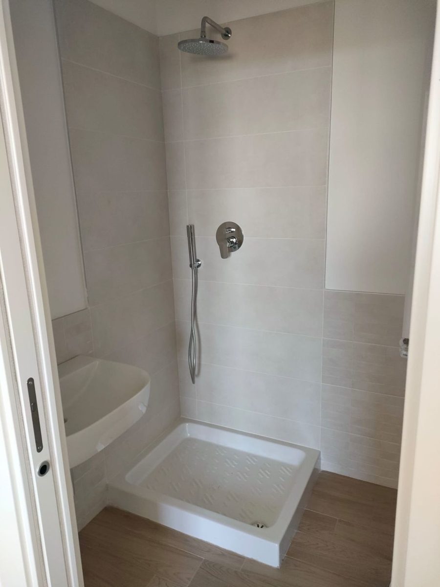 Prima: doccia con piatto bianco e piastrelle beige