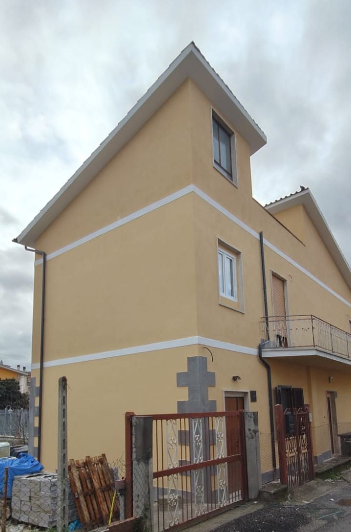Casa su tre piani con facciata gialla appena tinteggiata e fasce bianche