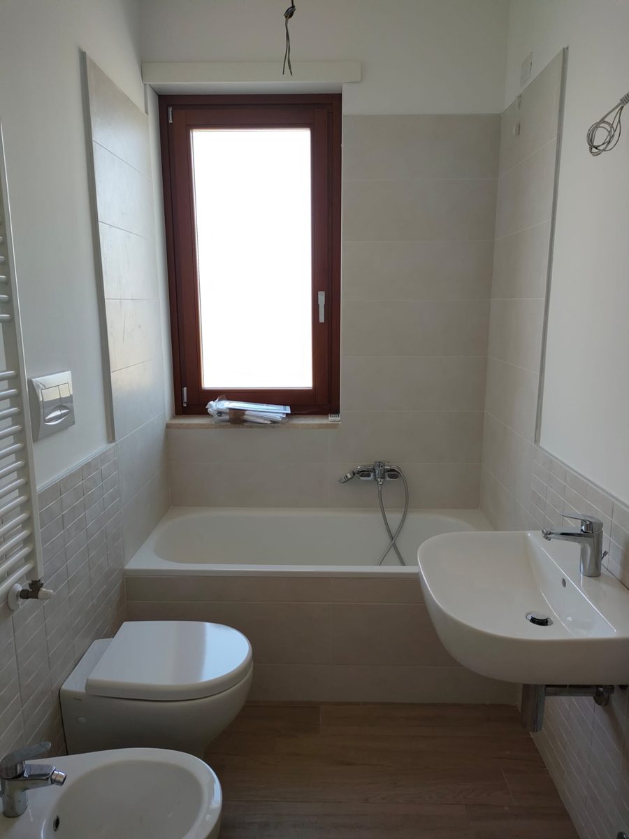 Prima: bagno con vasca e rivestimento beige