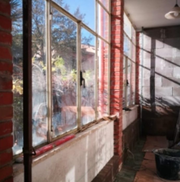 Prima: veranda con infissi in ferro e muri in mattoni